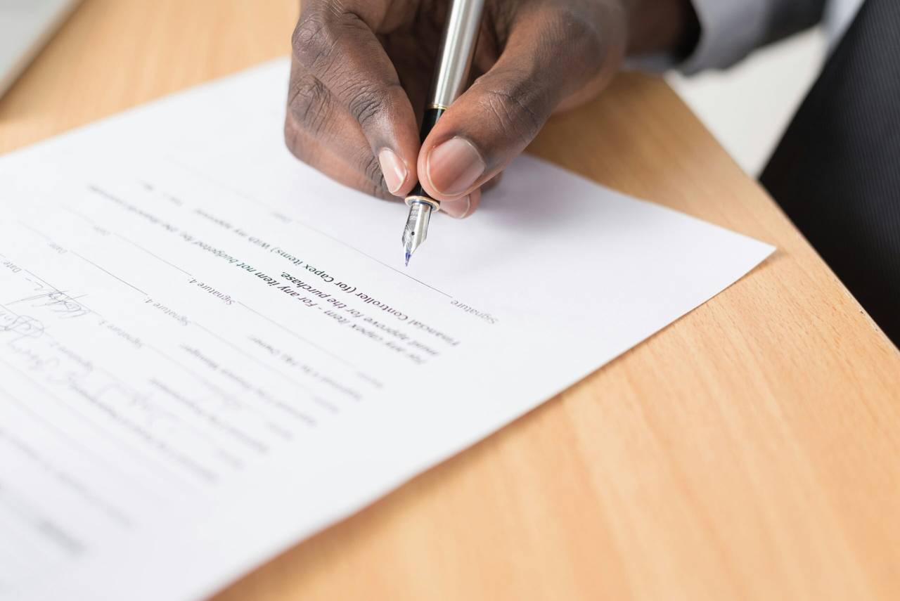 Close-up of a hand signing a last will and testament with a fountain pen